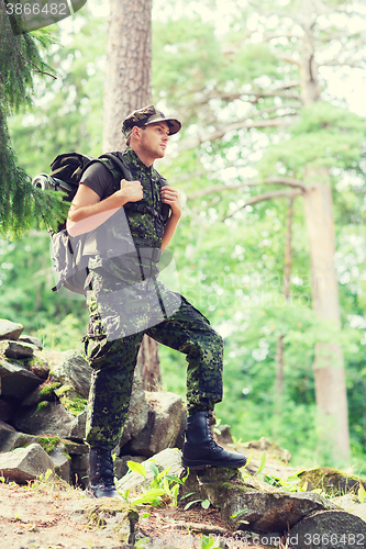 Image of young soldier with backpack in forest