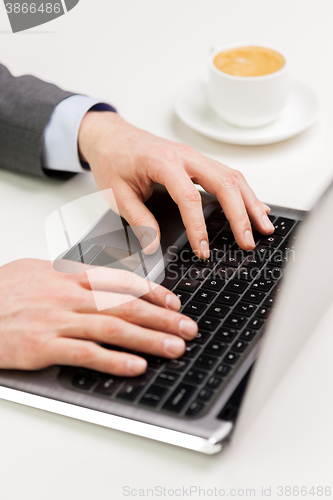 Image of close up of businessman hands typing on laptop