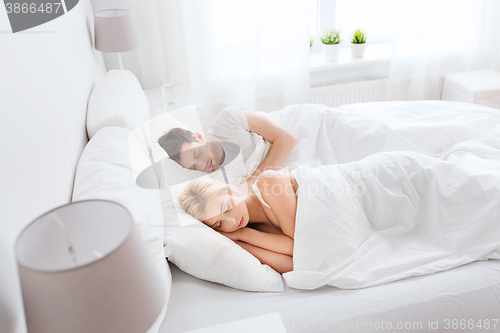 Image of happy couple sleeping in bed at home