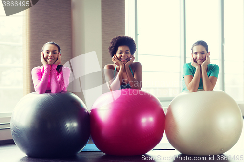 Image of group of smiling women with exercise balls in gym