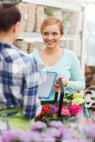 Image of happy women with tablet pc at flower shop