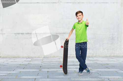 Image of happy boy with skateboard showing thumbs up