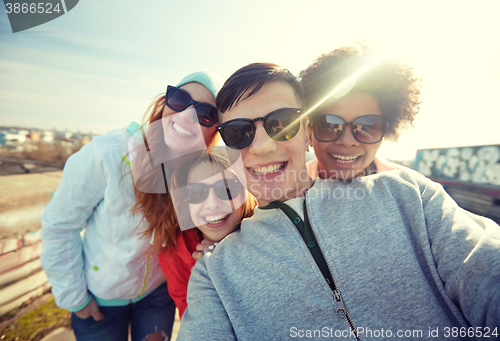 Image of group of happy friends taking selfie on street