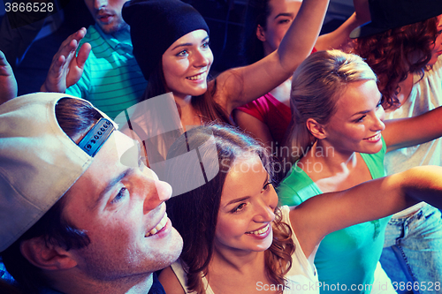 Image of smiling friends at concert in club