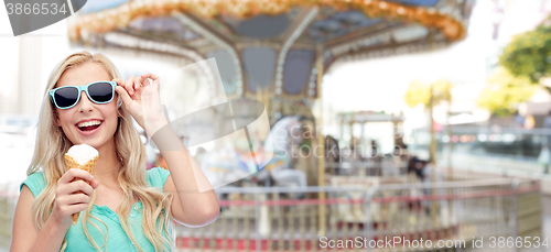 Image of happy young woman in sunglasses eating ice cream