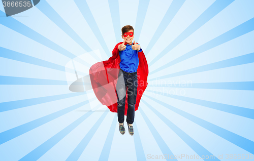 Image of boy in super hero cape and mask showing thumbs up