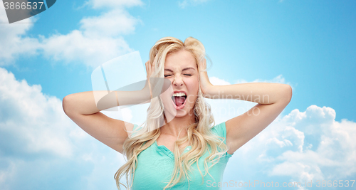 Image of young woman holding to her head and screaming