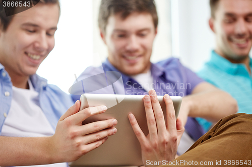 Image of close up of happy friends with tablet pc at home