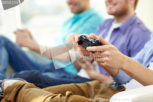 Image of close up of friends playing video games at home