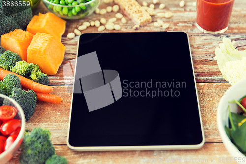 Image of close up of blank tablet pc screen and vegetables
