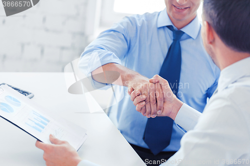 Image of businessmen shaking hands in office