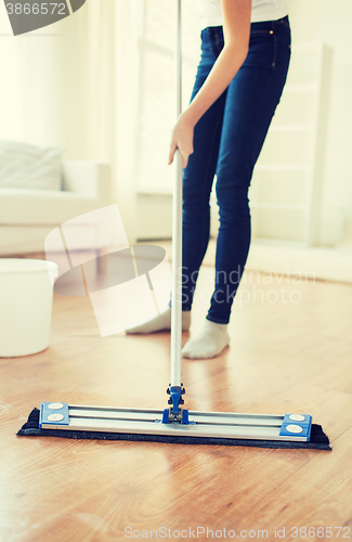 Image of close up of woman with mop cleaning floor at home