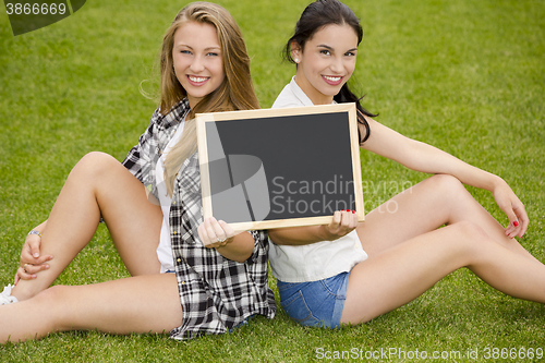 Image of Tennage students holding a chalkboard