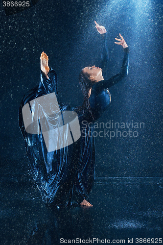 Image of The young beautiful modern dancer dancing under water drops