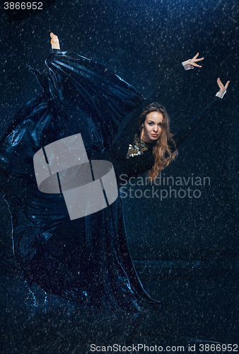 Image of The young beautiful modern dancer dancing under water drops
