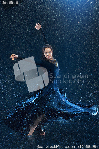 Image of The young beautiful modern dancer dancing under water drops