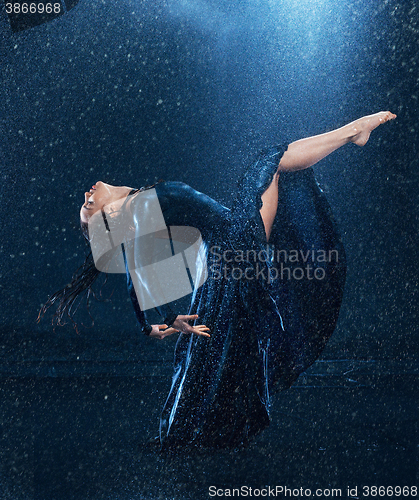 Image of The young beautiful modern dancer dancing under water drops