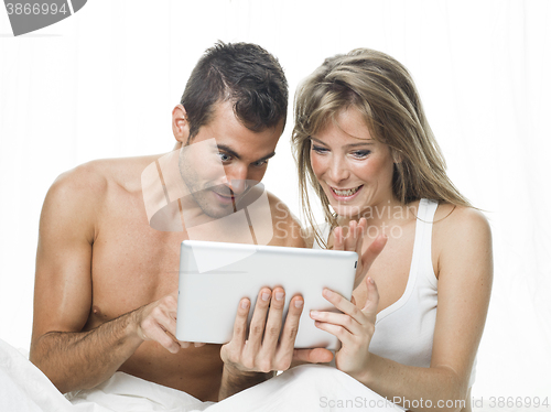 Image of attractive couple watching things in a tablet