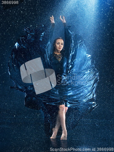 Image of The young beautiful modern dancer dancing under water drops