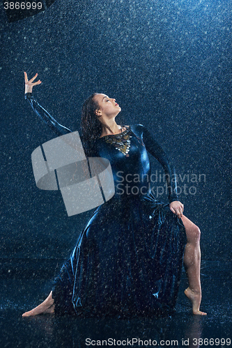 Image of The young beautiful modern dancer dancing under water drops