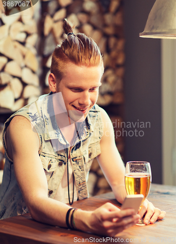 Image of happy man with smartphone drinking beer at bar