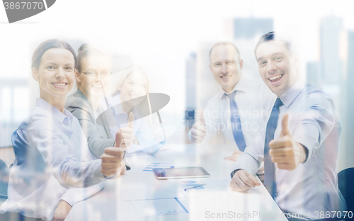 Image of business team showing thumbs up in office