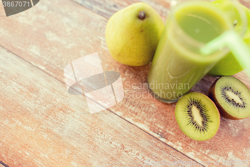 Image of close up of fresh green juice and fruits on table
