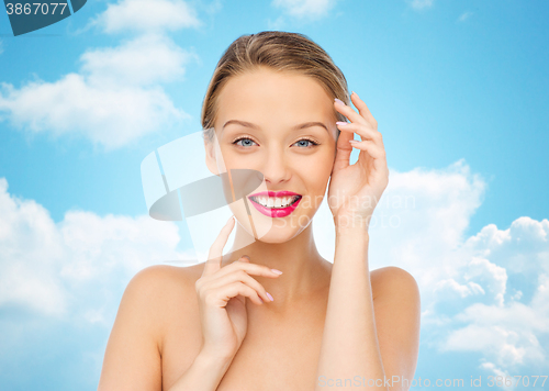 Image of smiling young woman with pink lipstick on lips