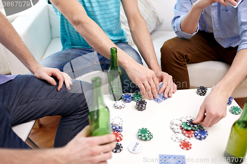 Image of close up of male friends playing cards at home