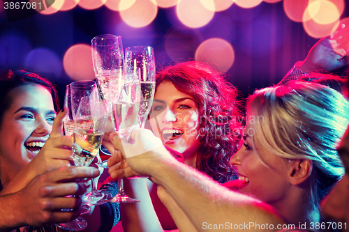 Image of smiling friends with glasses of champagne in club