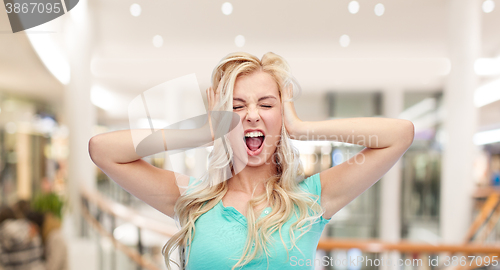 Image of young woman holding to her head and screaming