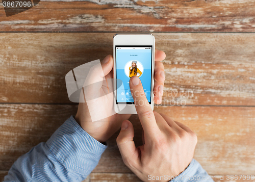 Image of close up of male hands with smartphone on table