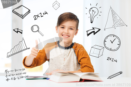 Image of happy student boy with textbook showing thumbs up