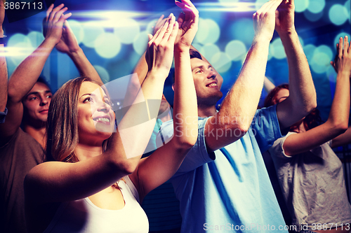 Image of smiling friends at concert in club