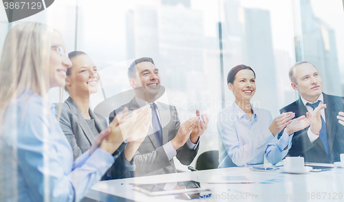 Image of business team with laptop clapping hands