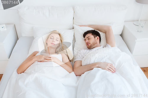 Image of happy couple sleeping in bed at home