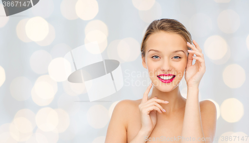 Image of smiling young woman with pink lipstick on lips