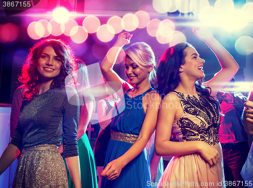 Image of smiling friends dancing in club