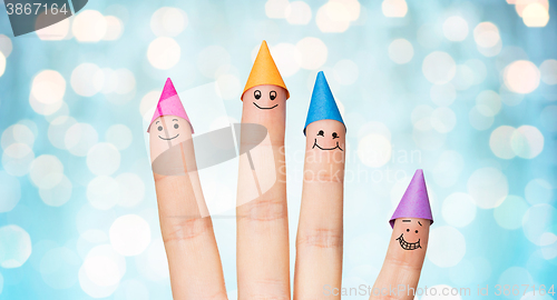 Image of close up of hand with four fingers in party hats