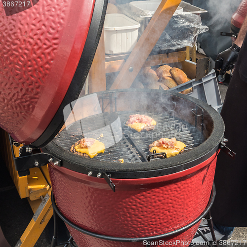 Image of Beef burgers being grilled on food stall grill.