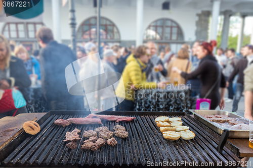 Image of Beef burgers being grilled on food stall grill.