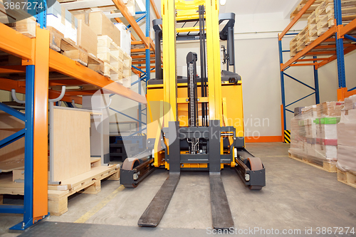 Image of Forklift, shelves and racks with pallets in distribution warehou