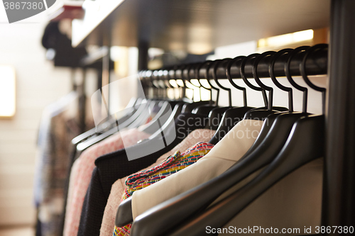 Image of Clothes on hangers in shop.
