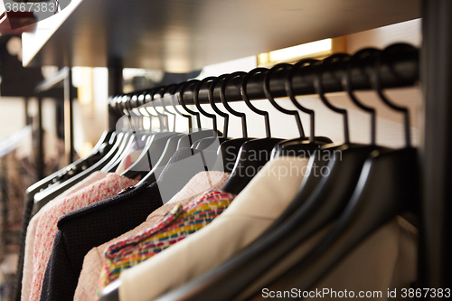 Image of Clothes on hangers in shop.