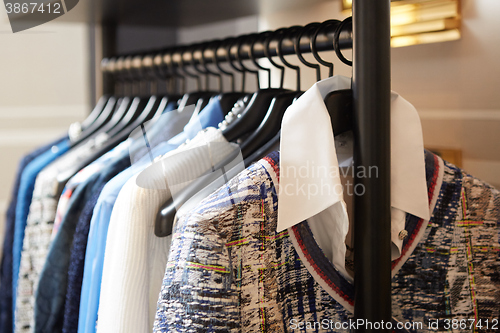 Image of Clothes on hangers in shop.