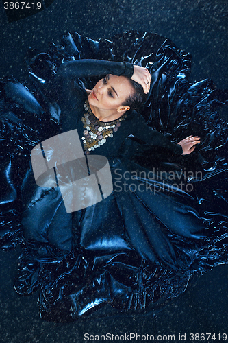 Image of The young beautiful modern dancer dancing under water drops