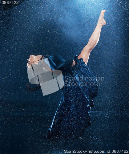 Image of The young beautiful modern dancer dancing under water drops