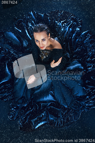 Image of The young beautiful modern dancer dancing under water drops
