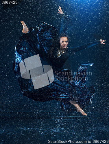 Image of The young beautiful modern dancer dancing under water drops