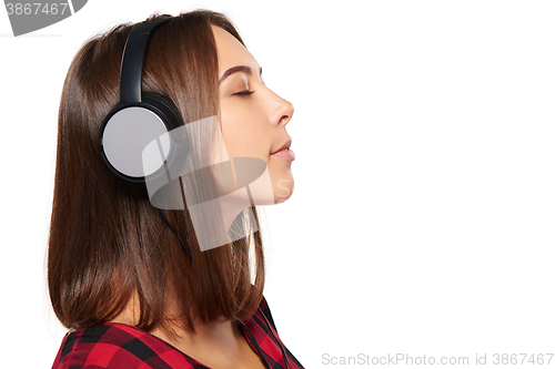 Image of Female listening enjoying music in headphones with closed eyes